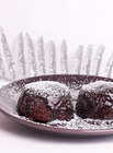 Chocolate pudding on brown plate with icing and silver christmas tree branch