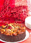 Christmas Cake on a white plate with a crystal glass on the red background