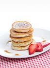 Pancakes with strawberry and maple syrup on a white plate