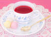 Tea Party, tea cup with rosy tea on a white plate with colorful marshmallow on a white and pink background