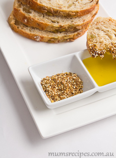 Dukkah Recipe with dukkah and olive oil and some rye bread on a white plate