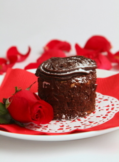 Valentine's Day Recipe of chocolate cake on white plate and red napkin and red rose and red patels